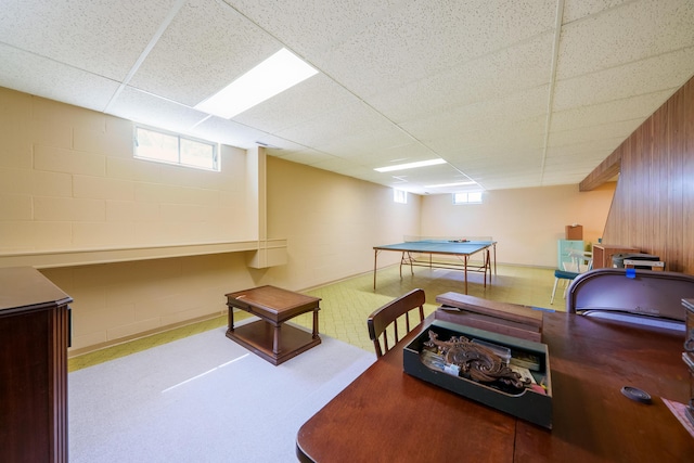 office area featuring a drop ceiling and concrete block wall