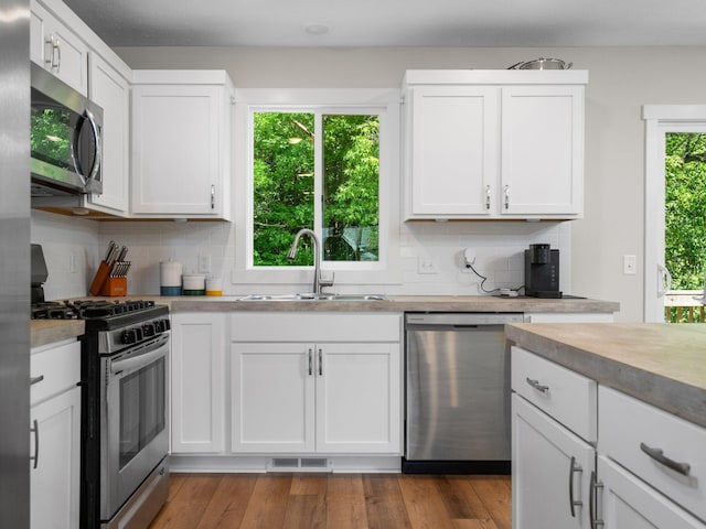 20630 Rolling Hills Ln, Big Rapids, MI 49307 - kitchen with appliances with stainless steel finishes, a sink, tasteful backsplash, and white cabinets
