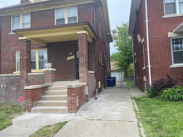 2474 Atkinson St, Detroit, MI 48206 - view of front of home featuring driveway, brick siding, and a gate