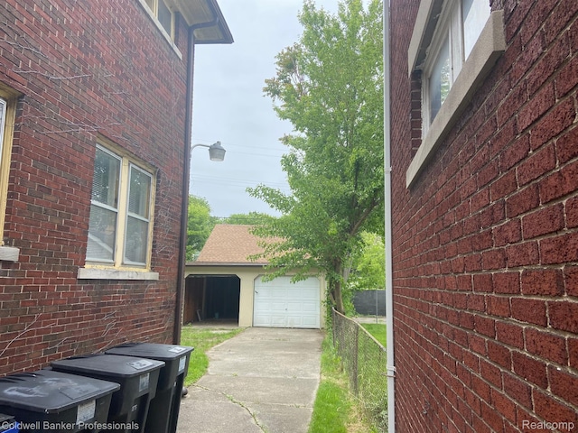 2474 Atkinson St, Detroit, MI 48206 - view of side of property with an outdoor structure, driveway, a garage, and brick siding
