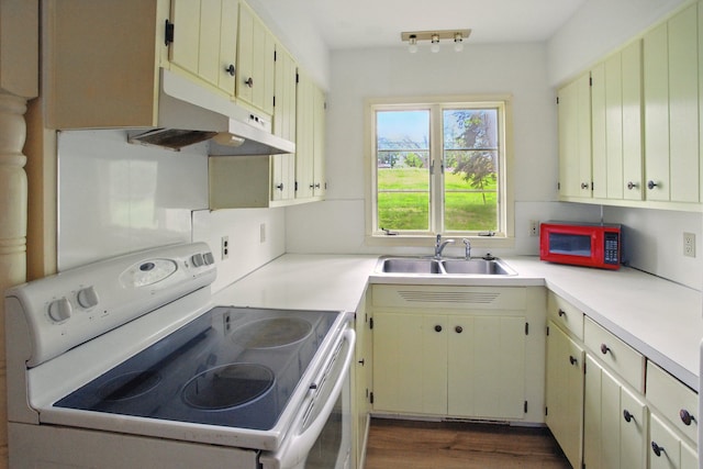 1469 Westwood Dr, Flint, MI 48532 - kitchen with white appliances, a sink, under cabinet range hood, light countertops, and dark wood-style flooring