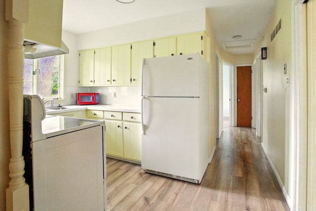 1469 Westwood Dr, Flint, MI 48532 - kitchen featuring white appliances, light wood-type flooring, a sink, and light countertops