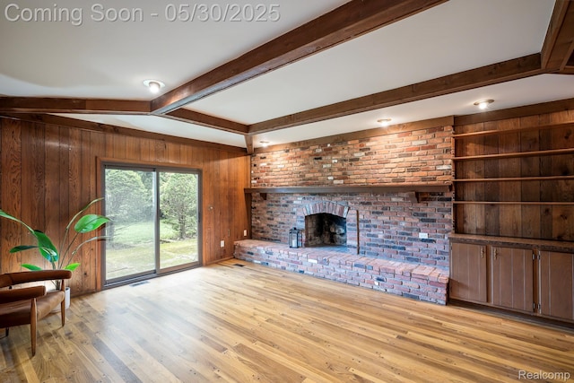 18851 Capitol Dr, Southfield, MI 48075 - unfurnished living room with wood walls, light wood-type flooring, and a brick fireplace