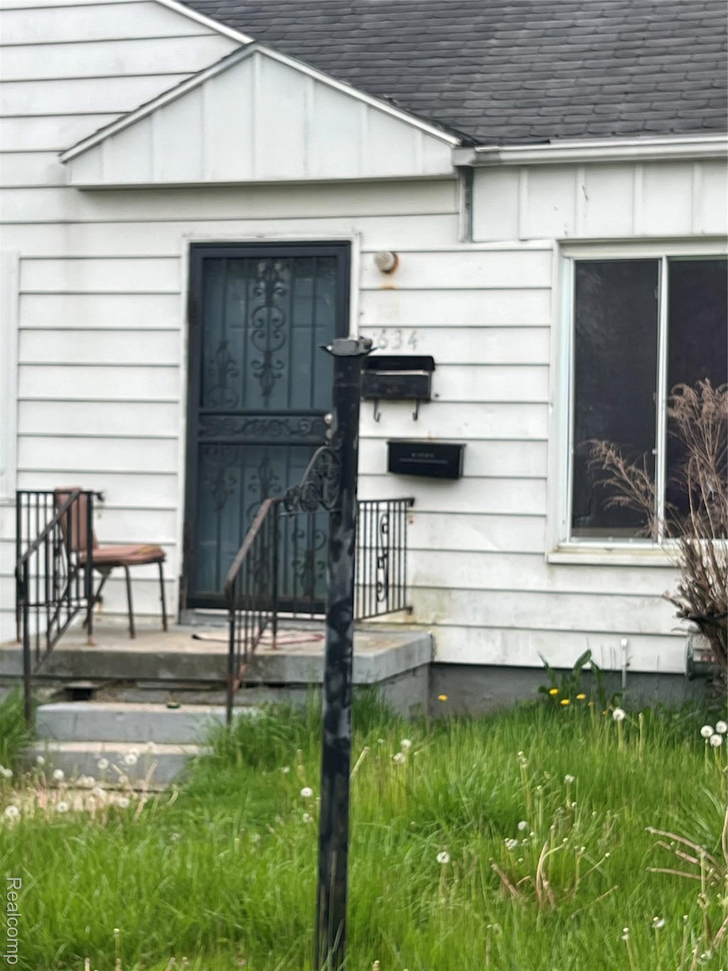 634 Spencer St, Flint, MI 48505 - property entrance featuring a shingled roof