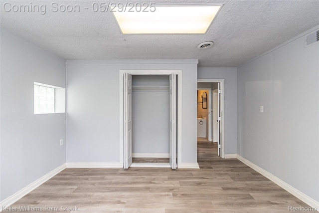 72 N Astor St, Pontiac, MI 48342 - unfurnished bedroom featuring a textured ceiling, light wood-style flooring, a closet, and baseboards