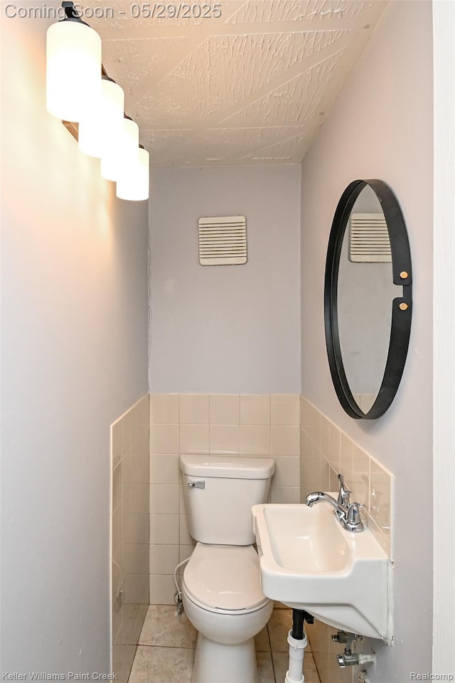 72 N Astor St, Pontiac, MI 48342 - half bath with toilet, tile patterned floors, a sink, tile walls, and wainscoting