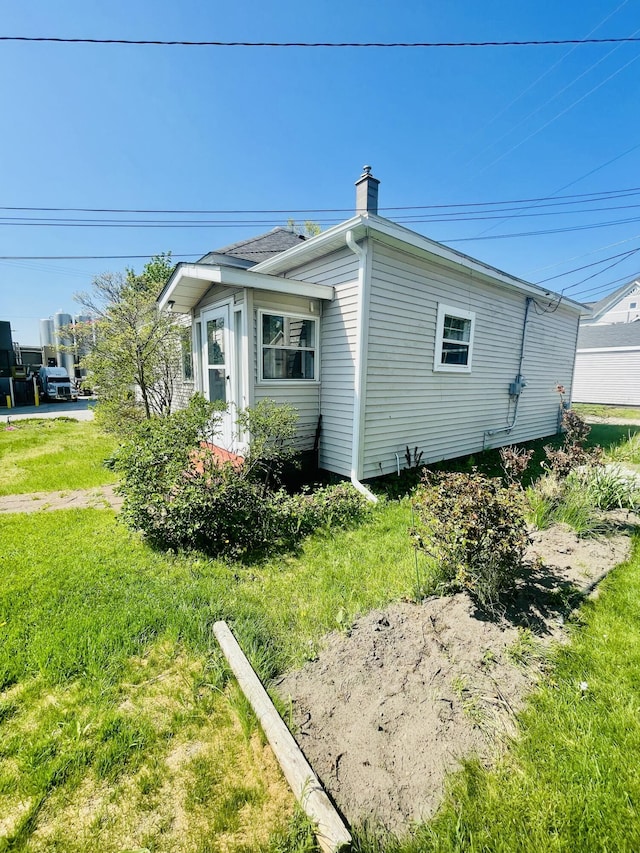 404 W Court St, Ludington, MI 49431 - view of property exterior featuring a yard and a chimney