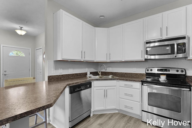 3514 River Run St, Wyoming, MI 49418 - kitchen featuring appliances with stainless steel finishes, a sink, dark countertops, and white cabinetry