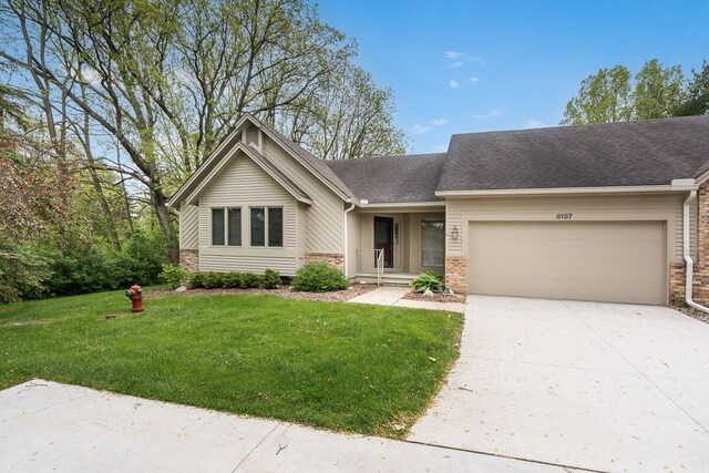 8187 Sawgrass Trl, Grand Blanc, MI 48439 - view of front of property featuring a garage, a front yard, concrete driveway, and roof with shingles