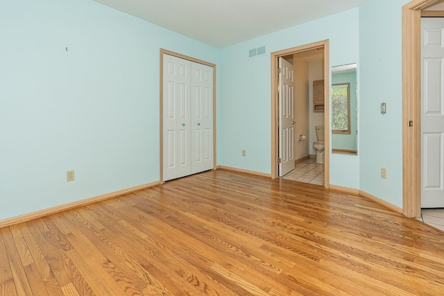 8187 Sawgrass Trl, Grand Blanc, MI 48439 - unfurnished bedroom featuring light wood-type flooring, baseboards, connected bathroom, and a closet