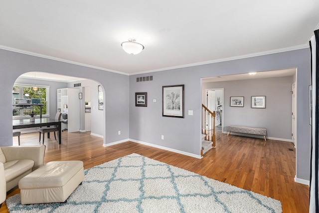 1817 High Pointe Ln, Ann Arbor, MI 48108 - living room featuring arched walkways, ornamental molding, wood finished floors, baseboards, and stairs