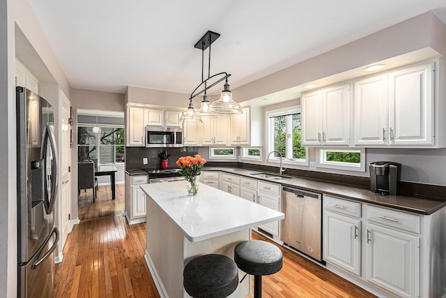 1817 High Pointe Ln, Ann Arbor, MI 48108 - kitchen featuring stainless steel appliances, a sink, light wood-style floors, and a center island