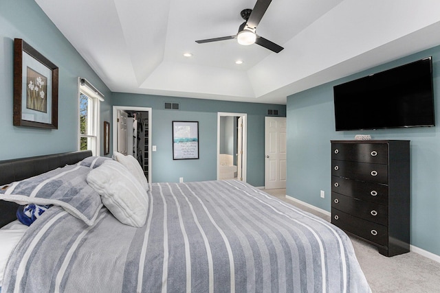 1817 High Pointe Ln, Ann Arbor, MI 48108 - bedroom with a tray ceiling, a walk in closet, light carpet, ensuite bathroom, and a ceiling fan
