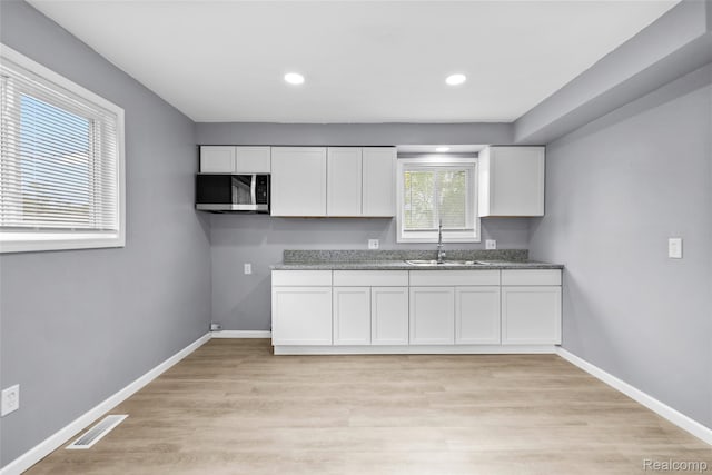 3907 Bayhan St, Inkster, MI 48141 - kitchen featuring stainless steel microwave, a sink, white cabinets, baseboards, and recessed lighting