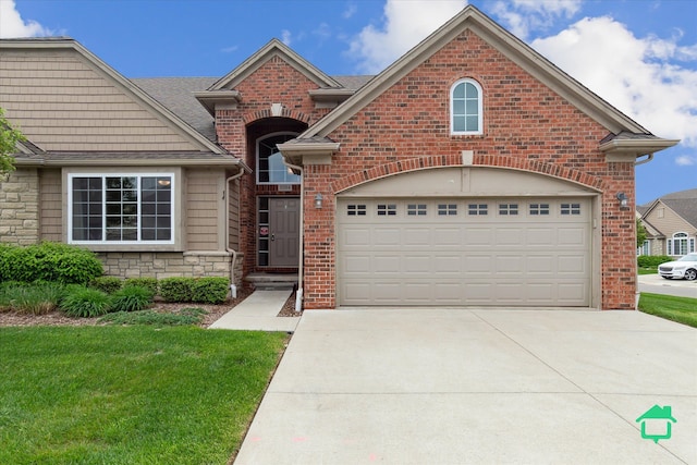 5104 Hawkseye Trce, Warren, MI 48092 - view of front facade featuring concrete driveway, a front yard, stone siding, brick siding, and an attached garage