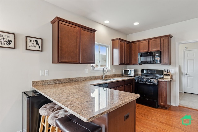 5104 Hawkseye Trce, Warren, MI 48092 - kitchen featuring black appliances, a sink, a peninsula, a breakfast bar, and recessed lighting