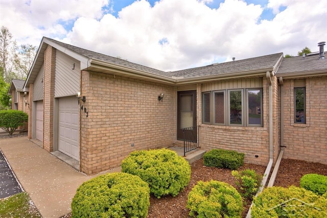 402 Morningside Dr, Midland, MI 48640 - view of front of house with an attached garage, brick siding, driveway, and roof with shingles