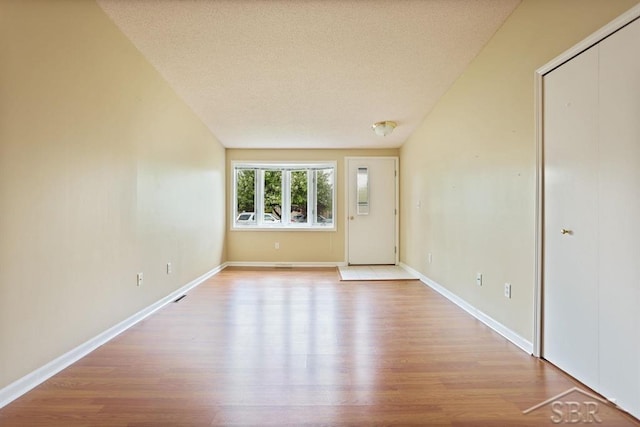 402 Morningside Dr, Midland, MI 48640 - empty room featuring wood finished floors, a textured ceiling, and baseboards