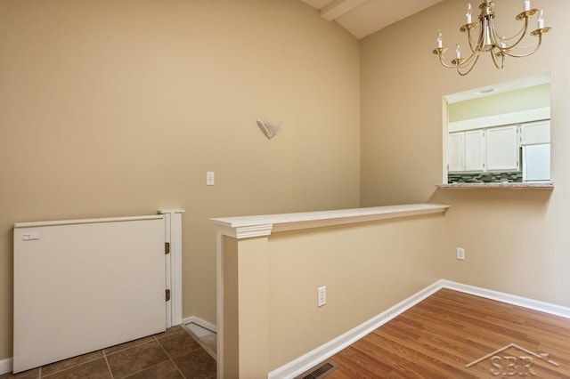 402 Morningside Dr, Midland, MI 48640 - corridor with a chandelier, vaulted ceiling, and baseboards