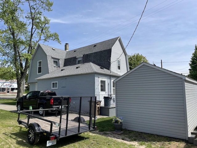 9 N Michigan Ave, Shelby, MI 49455 - back of house with roof with shingles, a gambrel roof, and a chimney
