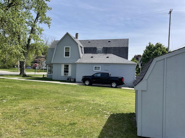 9 N Michigan Ave, Shelby, MI 49455 - view of home's exterior with a gambrel roof, a lawn, a shingled roof, and a chimney