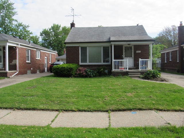 bungalow-style home featuring a porch, brick siding, a chimney, and a front yard