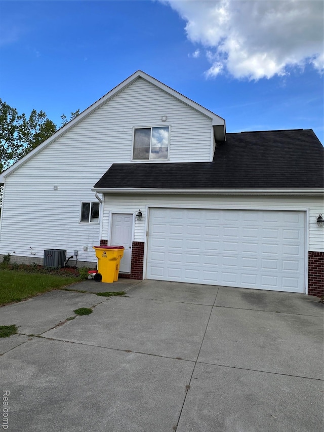 790 Vivian Ln, Oxford, MI 48371 - view of property exterior with concrete driveway, central AC, brick siding, and a garage