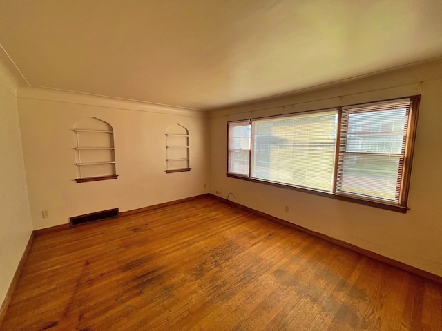 4057 High St, Ecorse, MI 48229 - spare room with wood finished floors, built in shelves, and healthy amount of natural light