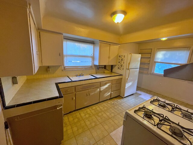 4057 High St, Ecorse, MI 48229 - kitchen featuring white appliances, healthy amount of natural light, extractor fan, and tile counters