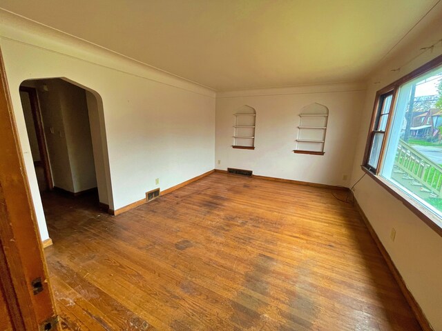 4057 High St, Ecorse, MI 48229 - empty room with arched walkways, wood-type flooring, and baseboards