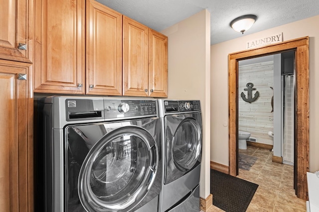 9861 W Doyle Dr, Mecosta, MI 49332 - laundry area featuring independent washer and dryer, cabinet space, baseboards, a textured ceiling, and light tile patterned floors