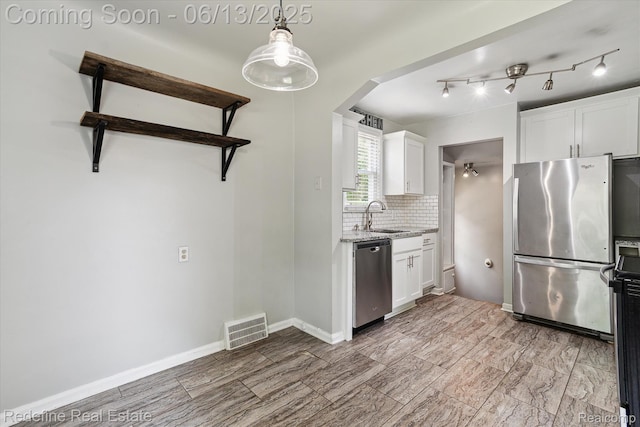 1976 Bacon Ave, Berkley, MI 48072 - kitchen featuring appliances with stainless steel finishes, white cabinetry, arched walkways, and light stone counters
