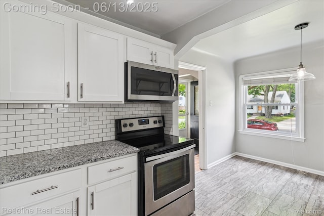 1976 Bacon Ave, Berkley, MI 48072 - kitchen with stainless steel appliances, backsplash, light stone counters, white cabinetry, and decorative light fixtures