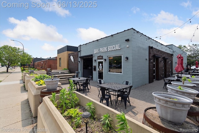 1976 Bacon Ave, Berkley, MI 48072 - back of house with concrete block siding, outdoor dining space, and a patio
