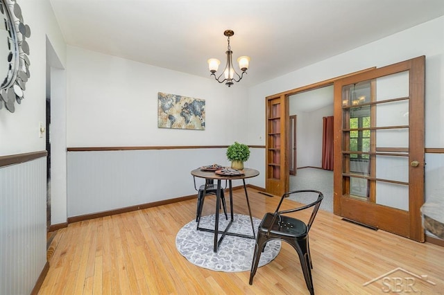 4215 Washington St, Midland, MI 48642 - dining area with light wood-type flooring, a chandelier, and baseboards
