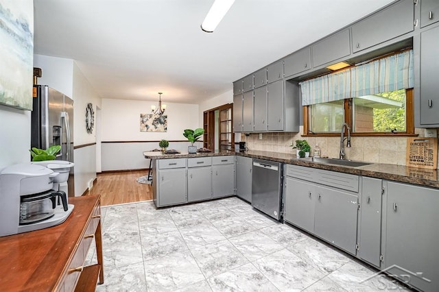 4215 Washington St, Midland, MI 48642 - kitchen featuring appliances with stainless steel finishes, a sink, gray cabinets, a peninsula, and a chandelier