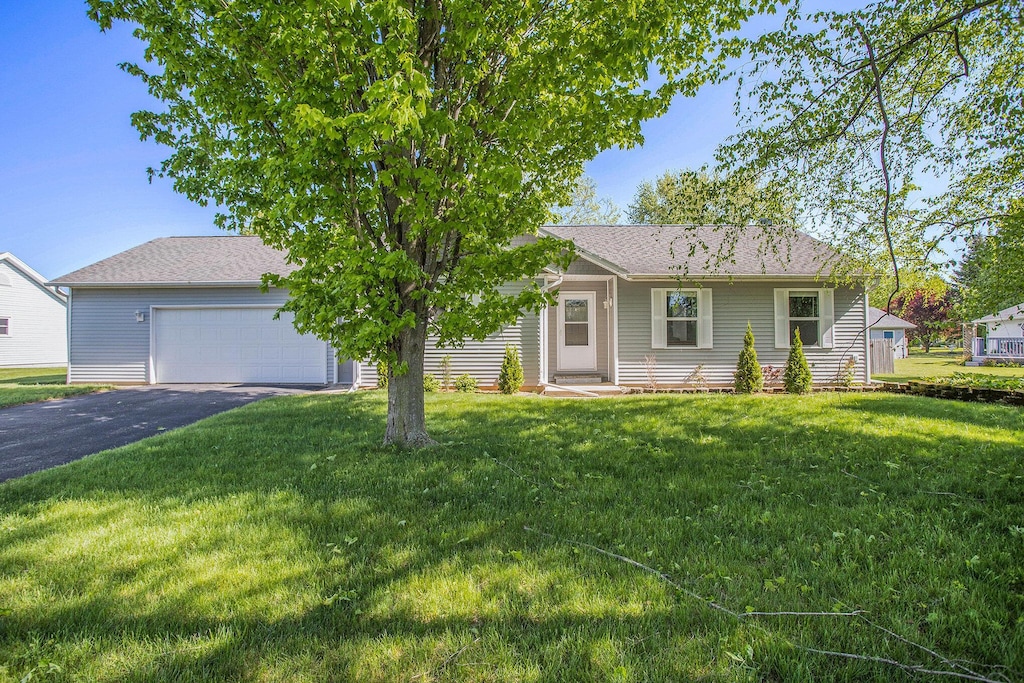 334 Thistle Ave, Climax, MI 49034 - view of front of house featuring asphalt driveway, a front yard, a garage, and a shingled roof