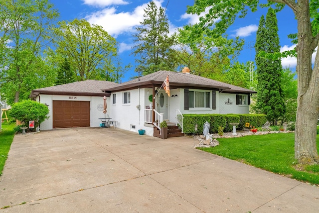 view of front of property featuring a chimney, an attached garage, driveway, a front lawn, and brick siding