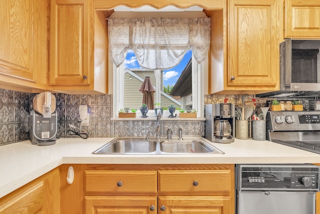 kitchen with stainless steel appliances, a sink, light countertops, and tasteful backsplash