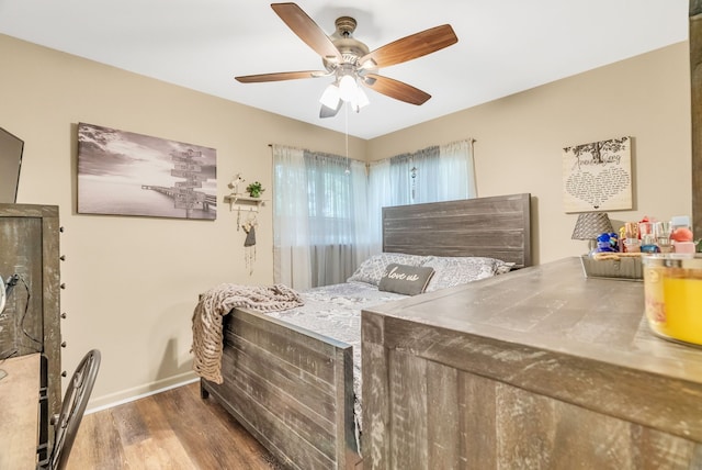bedroom featuring wood finished floors, baseboards, and ceiling fan