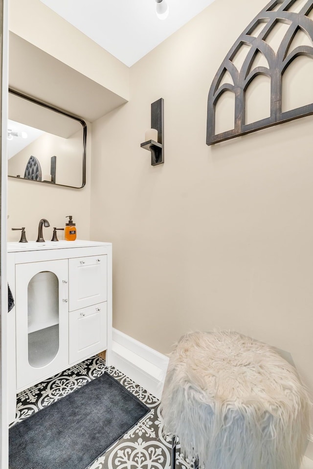 bathroom with baseboards, tile patterned flooring, and vanity
