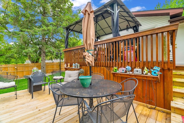 deck with outdoor dining area and a gazebo
