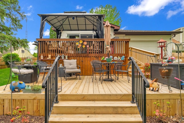 deck with outdoor dining area and a gazebo