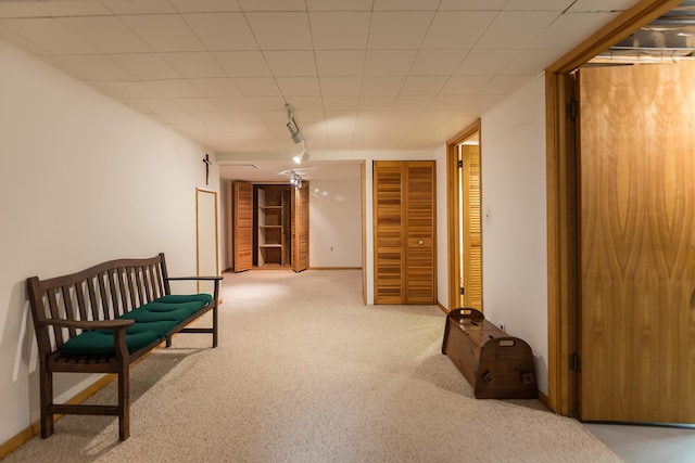 sitting room with carpet flooring, rail lighting, and baseboards