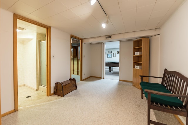 unfurnished room featuring carpet, rail lighting, and baseboards