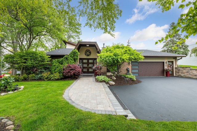 4749 Tara, West Bloomfield, MI 48323 - view of front of house featuring french doors, asphalt driveway, a front yard, a garage, and brick siding