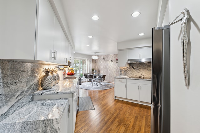 4749 Tara, West Bloomfield, MI 48323 - kitchen featuring a sink, under cabinet range hood, freestanding refrigerator, decorative backsplash, and white cabinets