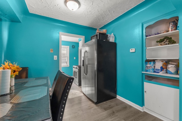 9069 Pierson St, Detroit, MI 48228 - kitchen featuring appliances with stainless steel finishes, light wood finished floors, a textured ceiling, and baseboards