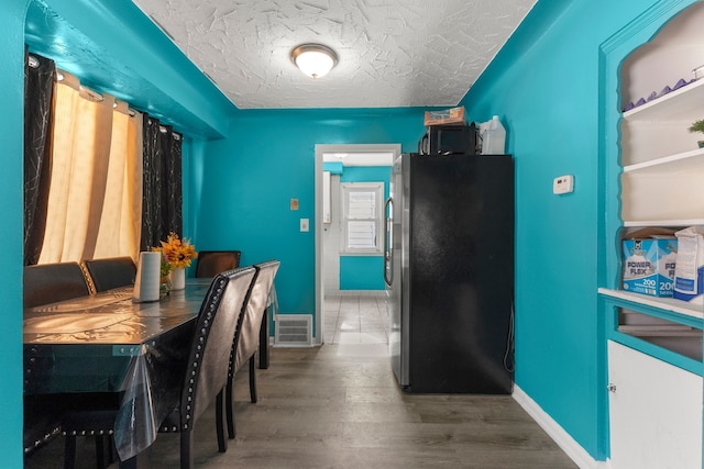 9069 Pierson St, Detroit, MI 48228 - dining room with baseboards, wood finished floors, and a textured ceiling