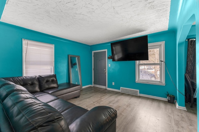 9069 Pierson St, Detroit, MI 48228 - living room featuring wood finished floors, baseboards, and a textured ceiling